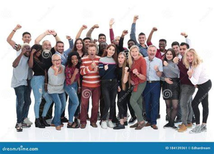 a group of people standing next to each other in front of a crowd holding signs
