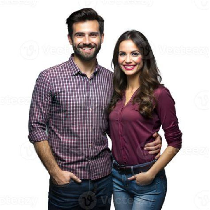 a man and woman standing together in front of a crowd at a sporting
