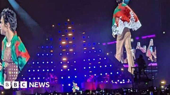 Harry Styles delights Cardiff crowd by donning Welsh flag BBC News