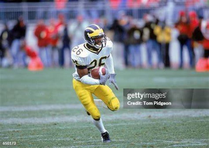 Julius Curry of the Michigan Wolverines leads the cheers as the team